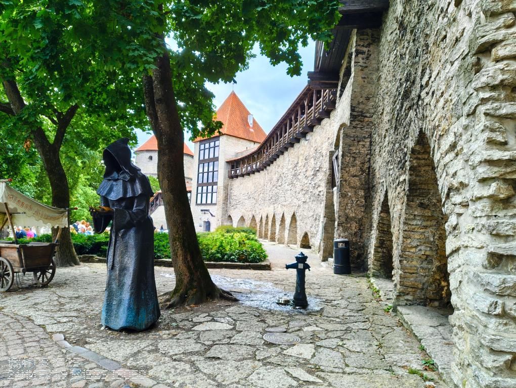 Burgmauer mit Statue und Brunnen